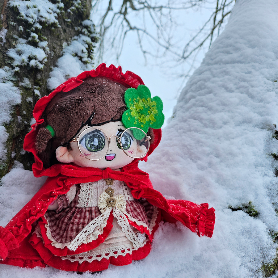 cloverdoll sitting in a tree, looking at the snow.